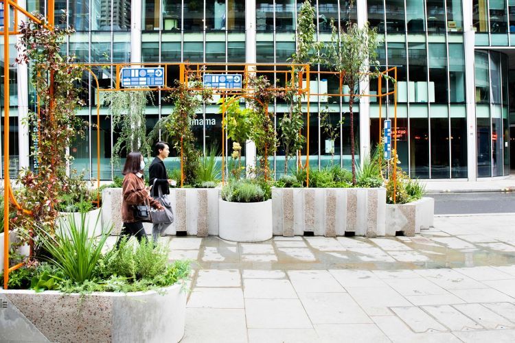 two people pass through a pop-up garden in the middle of the city. Photographer Em Davies.